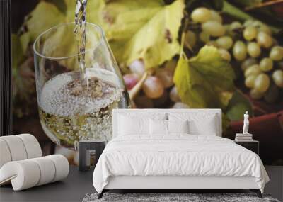 White wine being poured into a glass, vintage wood background, selective focus Wall mural