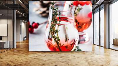 Winter alcoholic cocktail with red berries, liquor, gin, thyme and vodka for Christmas or New Year. Holiday table setting Wall mural