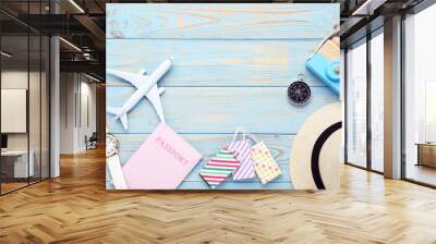 Airplane model with passport, shopping bags, hat and wrist watch on blue wooden table Wall mural