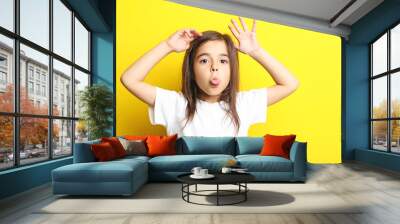 Beautiful little girl on yellow background Wall mural