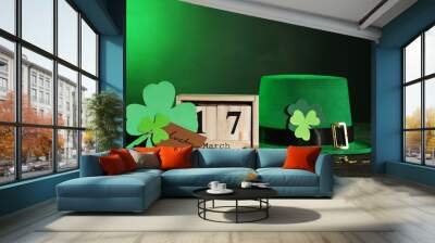 Clover leafs with wooden calendar, green hat and coins Wall mural