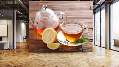 Cup of tea with mint and lemon on brown wooden table Wall mural