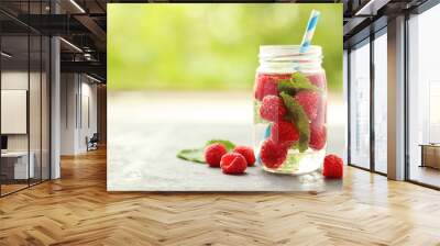 Detox water in bottle with berries on wooden table Wall mural