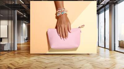 Female hand with bracelets and handbag on colorful background Wall mural