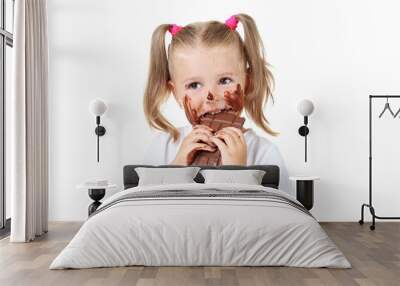 Happy little girl eating chocolate on white background Wall mural