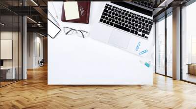 Laptop computer with glasses, smartphone, mouse and notepad on white background Wall mural