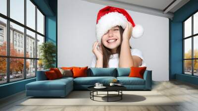 Little girl in christmas hat on grey background Wall mural