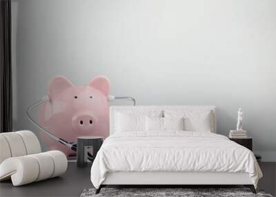 Pink piggy bank with stethoscope and coins on grey background Wall mural