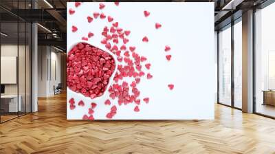 Red heart shaped sprinkles in bowl on white background Wall mural