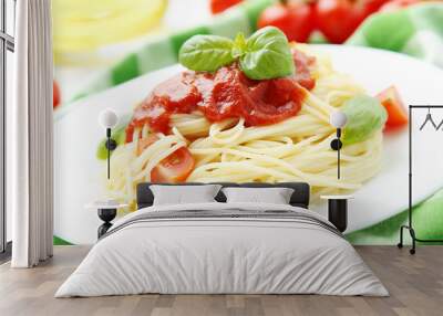 Spaghetti with tomatoes and basil on plate on white wooden backg Wall mural