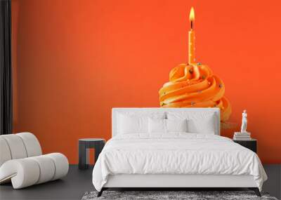 tasty cupcake with candle on orange background Wall mural