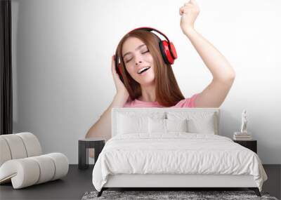 Young beautiful woman with headphones on white background Wall mural