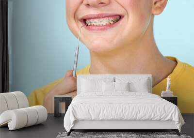 Young man with dentist tool on blue background Wall mural