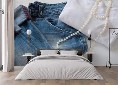 women's fashionable casual outfit - blue jeans, white sweater and white pearl necklace Wall mural