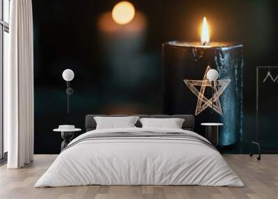 A black candle with a bright pentagram, glowing in the darkness, setting a mood of mysticism and intrigue. Wall mural