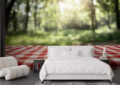 A classic red checkered picnic cloth spreads across an empty table, with a blurry natural background suggesting a tranquil outdoor setting. Wall mural