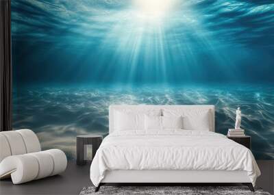 Empty underwater scene of the seabed with soft sand, beneath a calm, blue tropical ocean, illuminated by bright sunlight from above. Wall mural