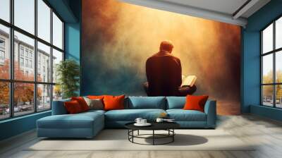 Man in deep prayer with a Bible, as a radiant light from above shines down, enveloping him in a divine connection and spiritual awakening Wall mural