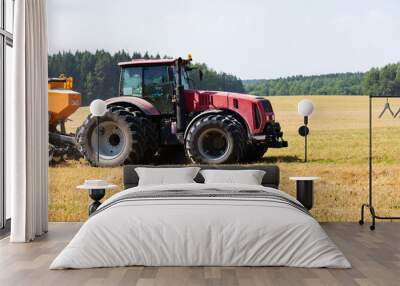 Tractor on the field harvests. Wall mural