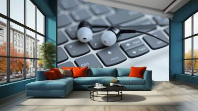 Black earphone, close up photo, on the laptop keyboard Wall mural