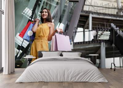 woman holding shopping bags. consumerism lifestyle in mall Wall mural