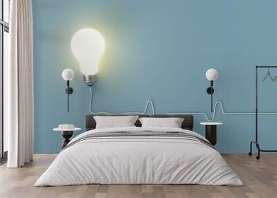 Minimal concept. outstanding glowing light bulb with cable on blue background for copy space. Wall mural