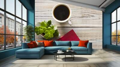 Stylish Business Office or Home Workplace Concept with a cup of black coffee, a plant in a pot and a red diary on a light wooden table, close up, top view Wall mural