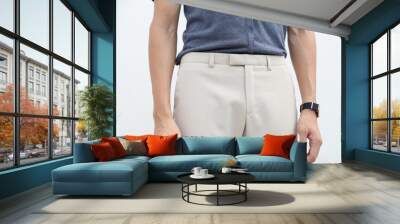 close-up of a handsome man in blue shirt and white long trousers. Wall mural