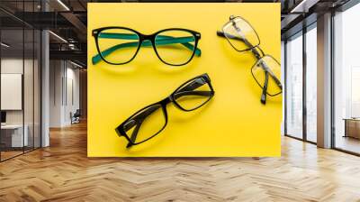 Accessories for eyes. Glasses with transparent lenses and different frames on yellow background Wall mural