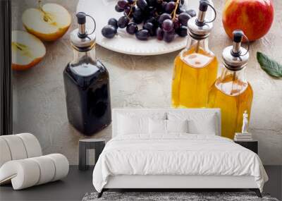 Apple cider and balsamic vinegar in bottles with grapes and red apples Wall mural