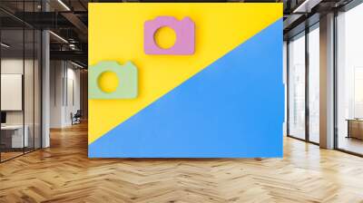 Blogger concept with photo camera on yellow and blue background top view mockup Wall mural