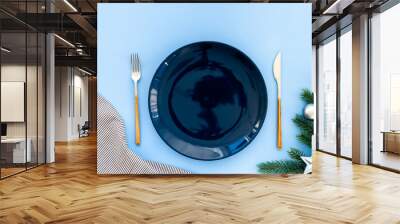 Blue colored table setting flatlay for Christmas and New Year Eve. Empty plate with cutlery and decoration, top view Wall mural