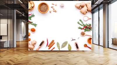 Colorful dry spices in bowls and spoons near ginger, garlic, rosemary, laurel leaf on white background top view copy space Wall mural