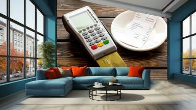 Credit card, bank terminal and restaurant bill on dark wooden background Wall mural