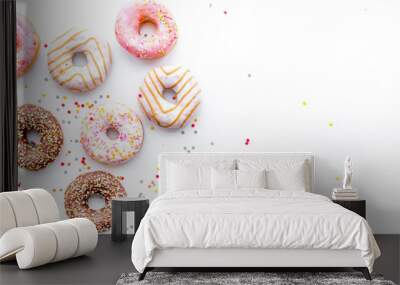 Donuts decorated icing and sprinkles on white background top view copy space pattern Wall mural