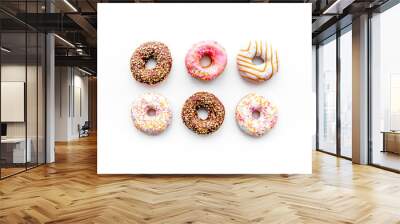 Donuts decorated icing and sprinkles on white background top view copy space pattern Wall mural