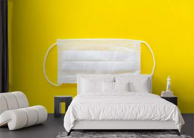 Flu prevention concept. Medical face mask on yellow background top view copy space Wall mural