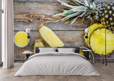 Freshly squeezed pineapple juice near fruit slices on wooden background top view Wall mural