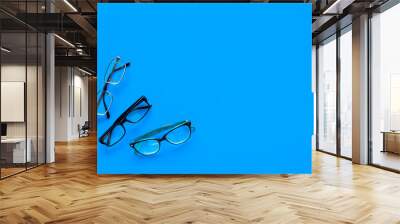 Glasses concept. Set of glasses with different eyeglass frame and transparent lenses on blue background top view copy space Wall mural