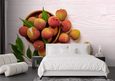 Lychee fruit with green leaf in wooden bowl, top view. Fresh ripe tropical fruit Wall mural