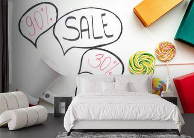 Sale concept with megaphone. Declare the sale. Electronic megaphone near word sale in cloud, gift boxes and sweets on white background top view Wall mural