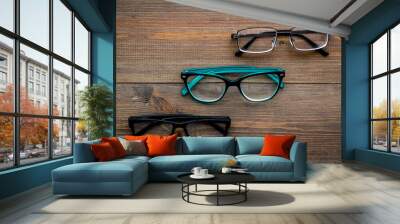 Set of glasses with transparent lenses on dark wooden background top view space for text Wall mural