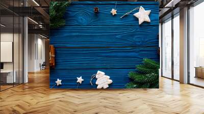 Spruce branch, cones and vintage toys in shape of spruce and stars on blue background for decoration on chrismas or new year top view copy space Wall mural