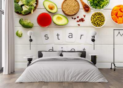 Start diet text near healthy food on white wooden background top view Wall mural