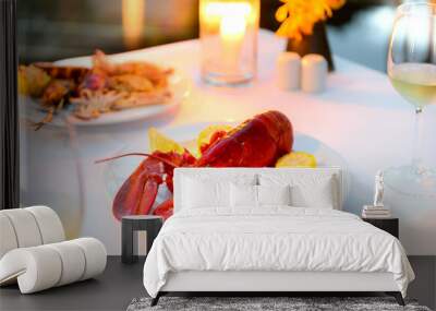 Luxury romantic candle light dinner setup by the pool with plate of lobster and seafood BBQ Wall mural