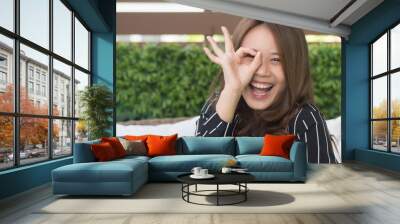 happy smiling girl staying home giving ok hand sign; portrait of relaxed cute happy smiling asian woman stays at home with approving, good, yes, accepting okay or ok gesture; young asian woman model Wall mural