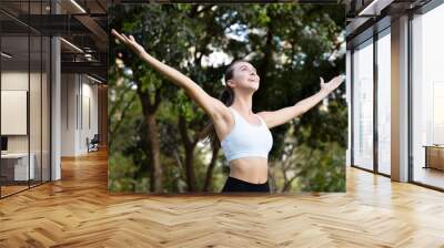 healthy happy relaxed young woman in park, arm opening for city nature sanctuary; concept of trees for environment, pleasant day, healthy lifestyle, people in nature, fresh air, woman summer lifestyle Wall mural