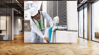 Professional African man working , engineer or manager wearing white helmet inspecting plumber system of the building Wall mural