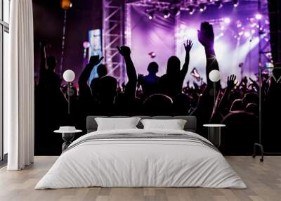 Men and women with raised hands at a concert event. Wall mural