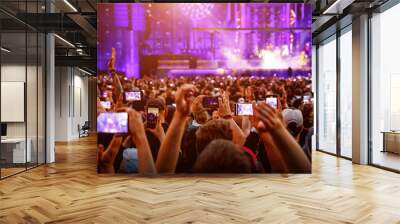 The crowd on a fan zone with the smartphone to record or take pictures during the live concert. Wall mural